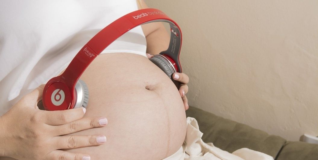 headphones on pregnant belly