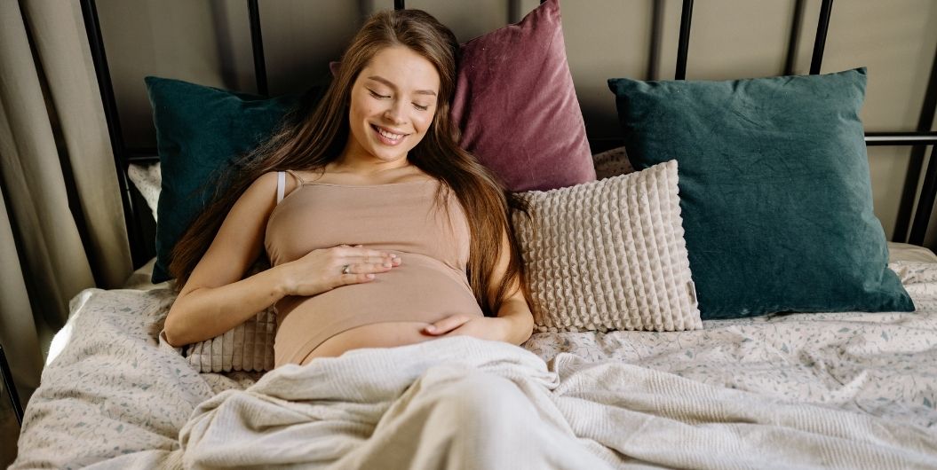 pregnant woman laying on bed