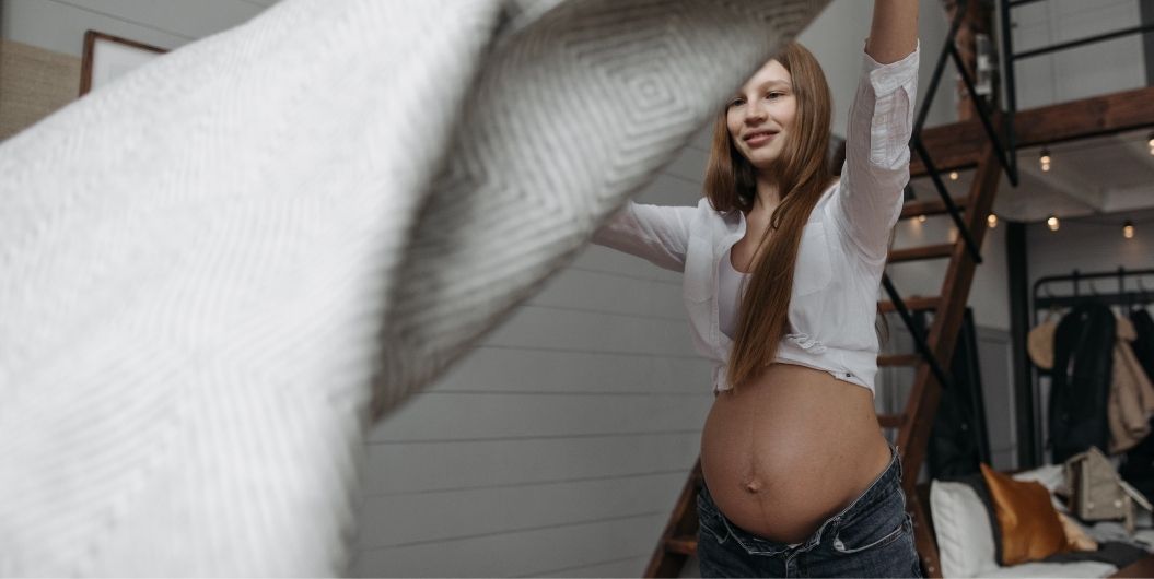 pregnant woman flipping blanket