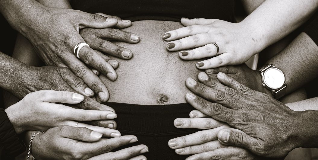 hands touching pregnant belly