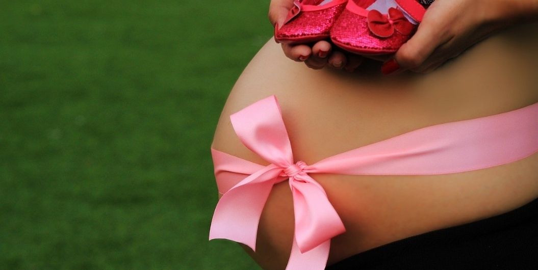 pregnant belly with pink ribbon