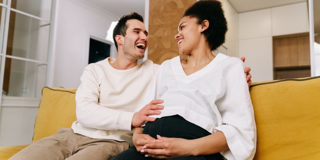 husband's hand on pregnant wife's belly